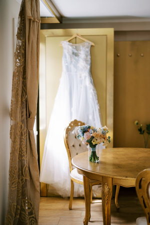 Elegant bridal bouquet and wedding dress in vintage room