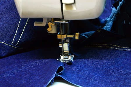 Laying a smooth stitch on denim on a sewing machine. Technology of textile processing. Sewing at home.の写真素材