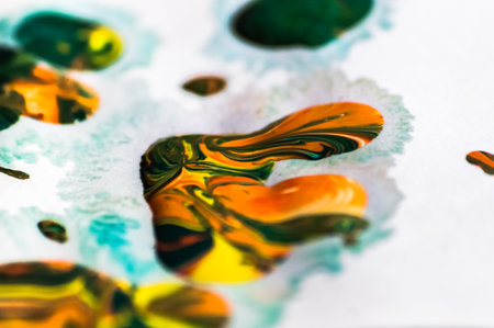 Close up shot of colorful acrylic paint splashes on white paper.の写真素材