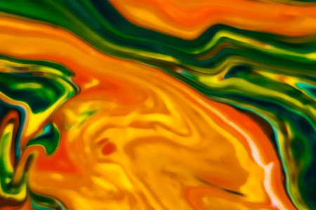 Abstract background of the colored liquid in yellow, orange and green