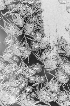 Frosty natural pattern on winter window glass. Winter background. The frosty pattern on the glass is...