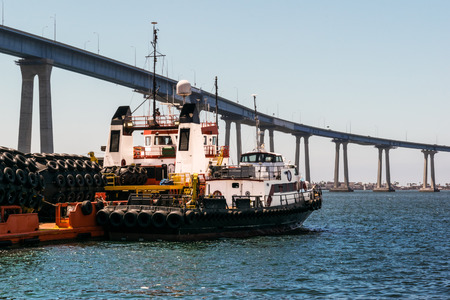 floating dock rubber fender at seaport in front of bridgeの写真素材