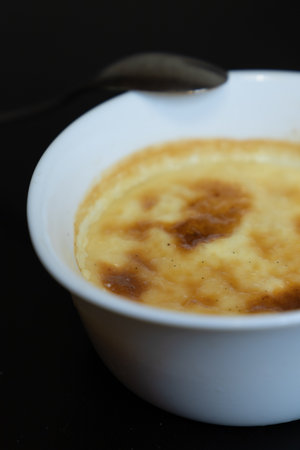 close up of a creme brulee a black background