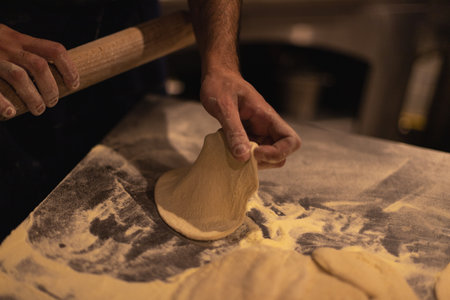 the cook rolls out the dough with a rolling pin. Table in flour