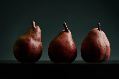 three red pears on a black tableの写真素材