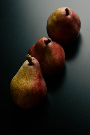 three red pears on a black tableの写真素材