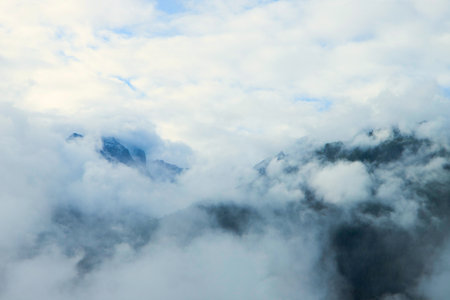 Amidst the Clouds: Alpine Peaks Dancing with the Skyの写真素材