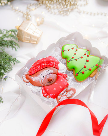 Christmas gingerbread cookies in the form of a festive bear, Christmas tree. Christmas decorations in the background with a fir branch.の写真素材