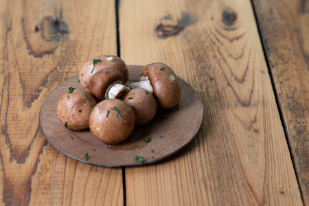 Champignon mushrooms in wooden plate on wooden background.の写真素材