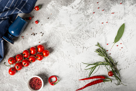 Fresh vegetables, a tomato branch, red peppers, herbs. Gray concrete textured background. Place for text.の写真素材