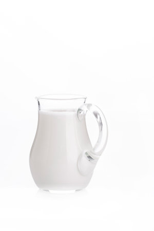 Glass jug pitcher of fresh milk isolated on white backgroundの写真素材
