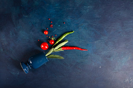 Top view of tomatoes, red hot chili peppers on a blue background. Place for text.