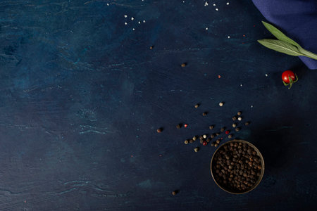 Spices, red peppercorns with herbs. On a blue background. Place for text.