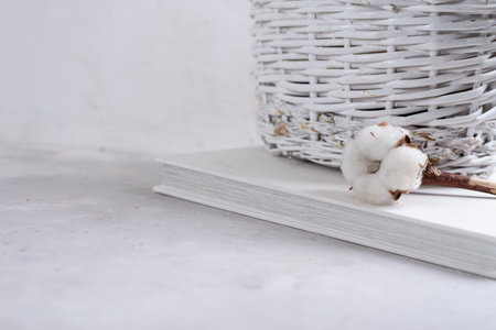 White wooden basket with beautiful decorative flowers, eucalyptus leaves on a gray textured background. Place for text. Close-up.の写真素材