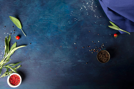 Spices, red and black peppercorns with herbs. On a blue background. Place for text.の写真素材