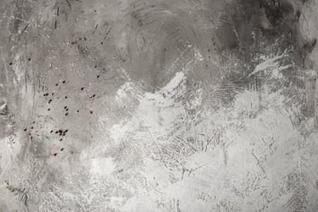 Red and black peppercorns on a gray textured background.