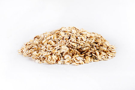 Oat flakes isolated on white background. Heap shaped side view.