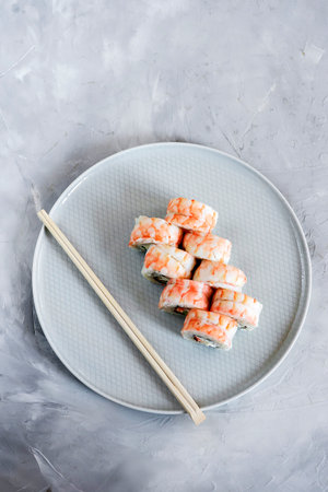 Japanese sushi close-up. Top view on white plate, light gray textured background.の写真素材