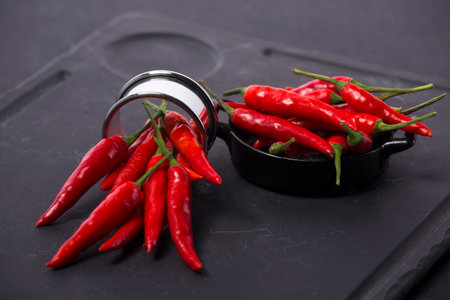 Many peppers laid out on a chopping board in blackの写真素材