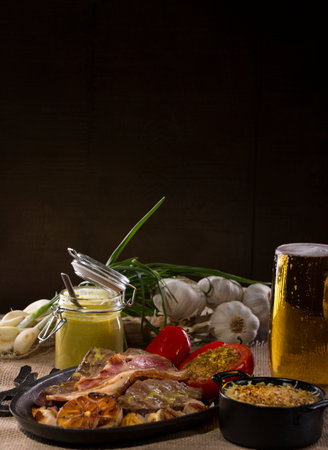 Still Life food dish of veal liver with bacon and tomato baked with pistachios, roasted garlic, mustard and a pot of mashed potatoesの写真素材
