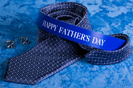 Blue tie and cufflinks on a blue marble background for the holiday Father's Day