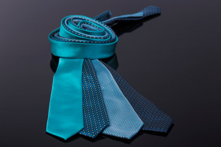 silk ties in different colors, spread out on a black tabl