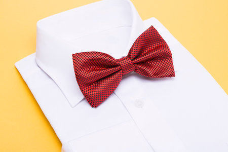 Red bow tie on a white shirt, yellow backgroundの写真素材