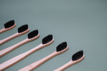 Natural bamboo brushes on a green background. Eco-friendly oral hygiene products.