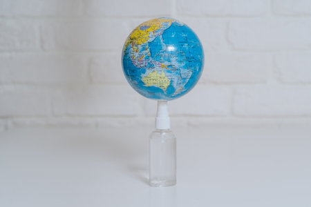 Help antiseptic in the epidemic. The globe is treated with an antiseptic in disposable gloves. Disinfection of surfaces from viruses and bacteria.の写真素材