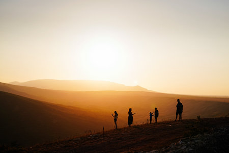 Silhouettes of people at sunset. Beautiful fiery sunset. People admire the sunsetの写真素材