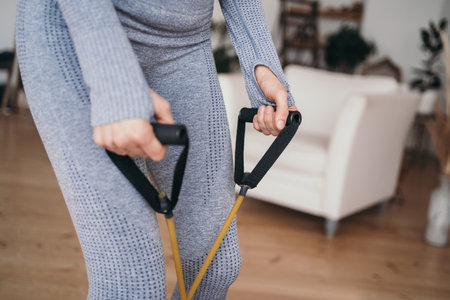 Doing sports at home online. Exercise with an expander. Expander close-up at work