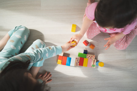 Preschool games. Children play with wooden cubes. The child passes the red cube. Kids build houses.