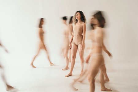 The girl got lost in the crowd. One person is clear, and the crowd is smeared. The girl confidently stands among the running peopleの写真素材