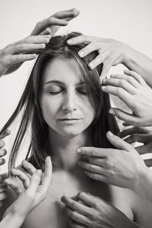 The impact of the environment on humans. A beautiful curly woman looks into the frame. Lots of hands...