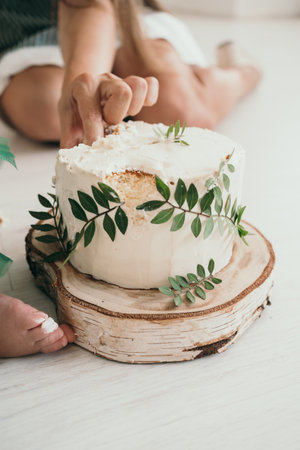Cake with cream cheese decorated with eucalyptus leaves. Handmade homemade cake. Wooden tray of birch sawn.の写真素材