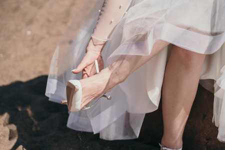 The bride wears shoes. The girl was tired of wearing shoes with heels. The woman takes her shoes off her feet.の写真素材