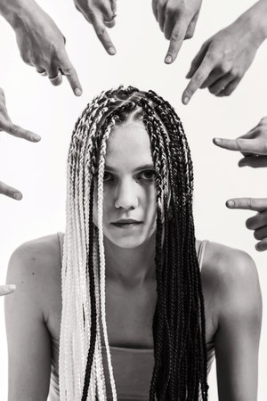 The girl is condemned by society. Original girl with African pigtails. Everyone points the finger at the girl. Strong personality vs. systemの写真素材