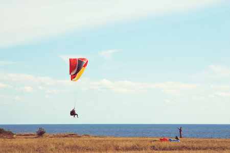 paragliders training by the sea shore in autumnの写真素材