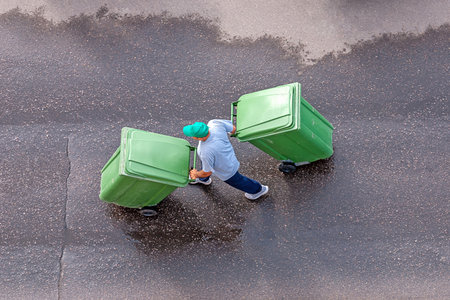 garbage man at work moving trash containers, top view