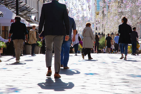 man in business suit is walking away along pedestrian street, people strolling on sunny day, Kamergerskiy pereulok, Moscow 28/08/2019のeditorial素材