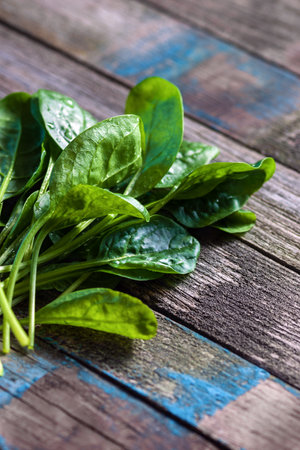 spinach leaves on textured old wood planks, vertical closeupの写真素材