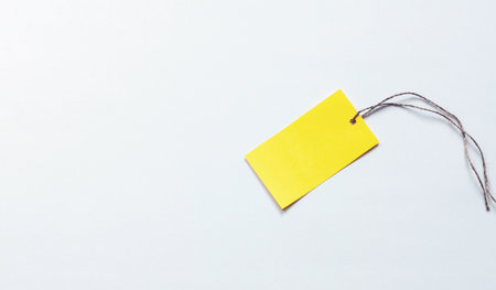 Yellow paper label on white pink background, place for logo, text, discount or advertisement