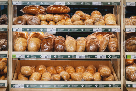 Various kinds of fresh bread in plastic packages for sale on supermarket shelves, Moscow, 28 Oct 2021のeditorial素材