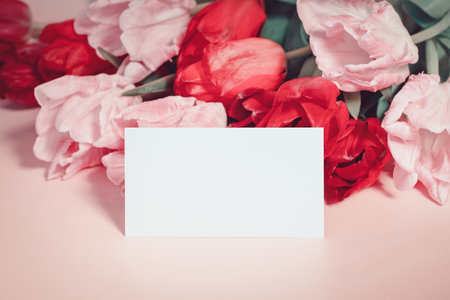 Flowers and paper card mockup, pink tulips with place for textの写真素材