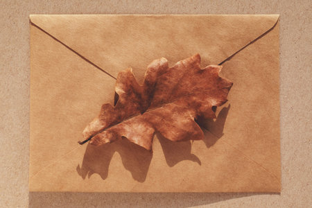 Oak leaf on brown paper envelope, minimal fall background, autumn flat layの写真素材