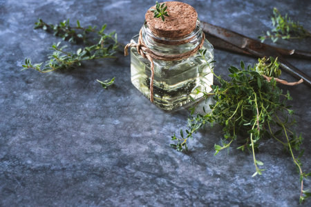 Thyme oil in bottle, freshly cut Thymus serpyllum leaves on table, copy spaceの写真素材