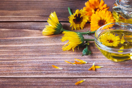 Calendula herbal infused oil made of Calendula officinalis flowers on wooden background, copy spaceの写真素材
