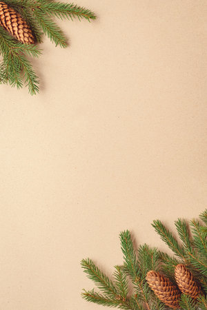 Christmas tree branches on brown paper background, spruce twigs and cones flat lay, copy space