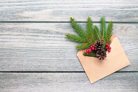 Christmas tree twigs in paper envelope on wooden background, eco sustainable decorations trendの写真素材