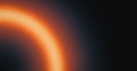 Glowing burning ring dark background, grainy gradient orange red yellow black noise texture banner abstract backgroundの写真素材